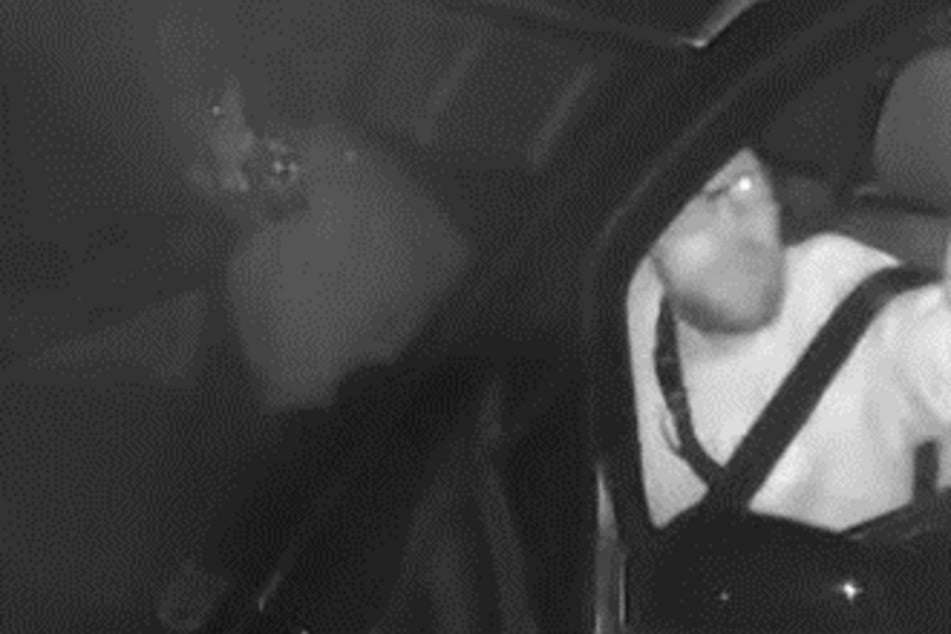 Der Mann hinter dem Steuer trug eine Brille, eine lange Halskette und eine Bauchtasche.