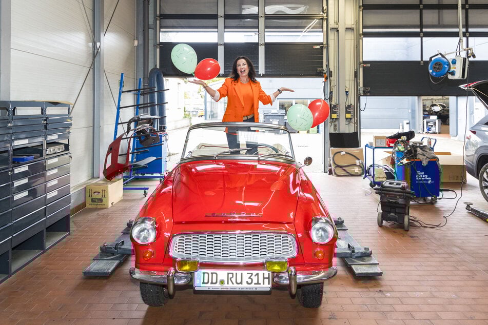 Die Liebe zu Skoda ist ihr ins Gesicht geschrieben: Autohaus-Chefin Simone Rüdiger jubiliert im knallroten Skoda Felicia.