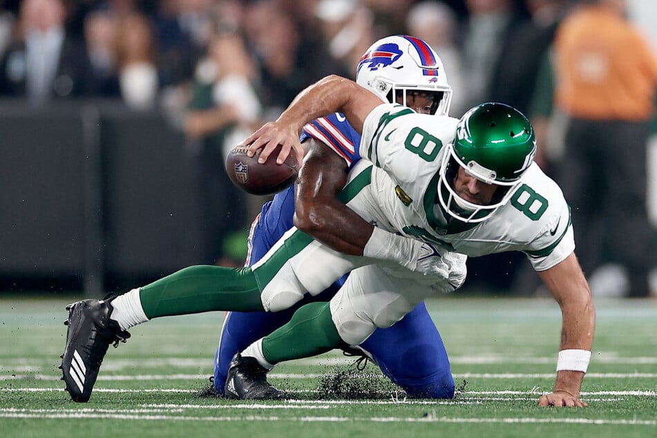 The moment of his season ending – in his first game for the Jets: Aaron Rodgers (40, right) is fairly brought to the ground by Bills defender Leonard Floyd (31). Rodgers' Achilles tendon tears.