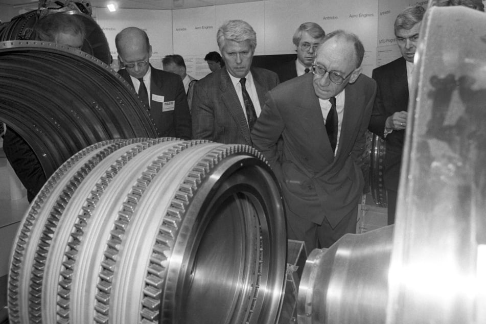 Im Jahr 1990: Reuter (r.) schaut sich während eines Rundgangs auf der Internationalen Technologiemesse für Luft- und Raumfahrt in Hannover Teile eines Triebwerks an.