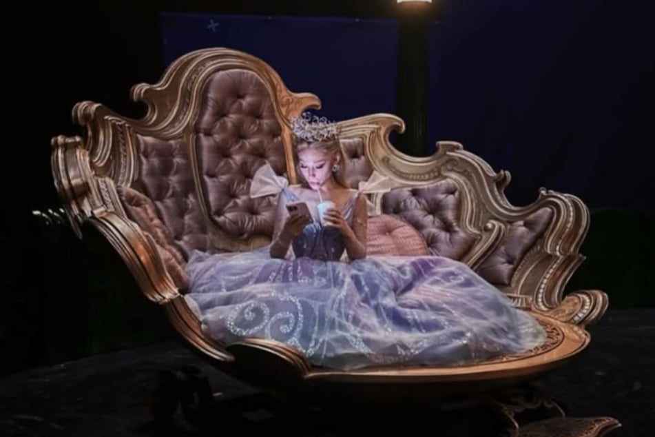 Ariana Grande lounges in her Glinda bubble in a behind-the-scenes snap.