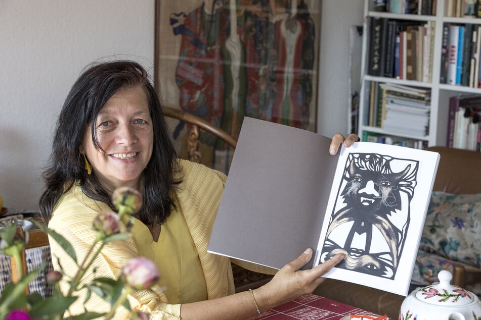 Irene Wieland mit dem Begleitbuch zur Schau "Sehnsucht nach dem Paradies" in Hoflößnitz. Dort kann man auch das Original dieses Filz-Scherenschnittes bewundern.