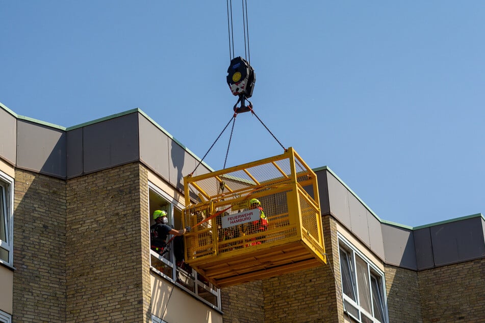 Mit Hilfe eines Krans wird der Mann aus seiner Wohnung transportiert.