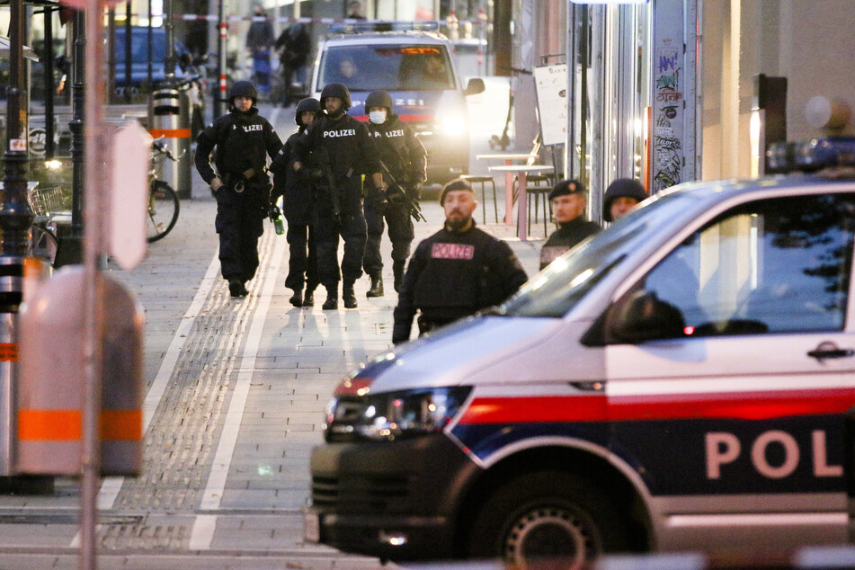 Bewaffnete Polizisten patrouillieren am frühen Morgen auf einer abgesperrten Straße nach einem Schusswechsel im Stadtzentrum.