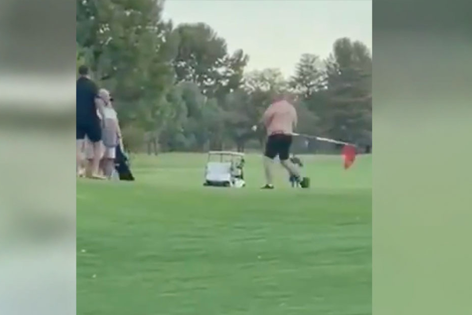 One of the two men grabbed the flag pole from the putting green and started hitting the other man.