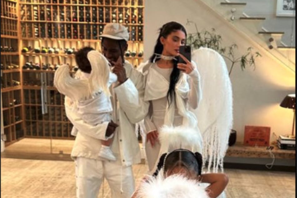 Kylie Jenner (r), Travis Scott, and their two children sport angelic costumes for this past Halloween.