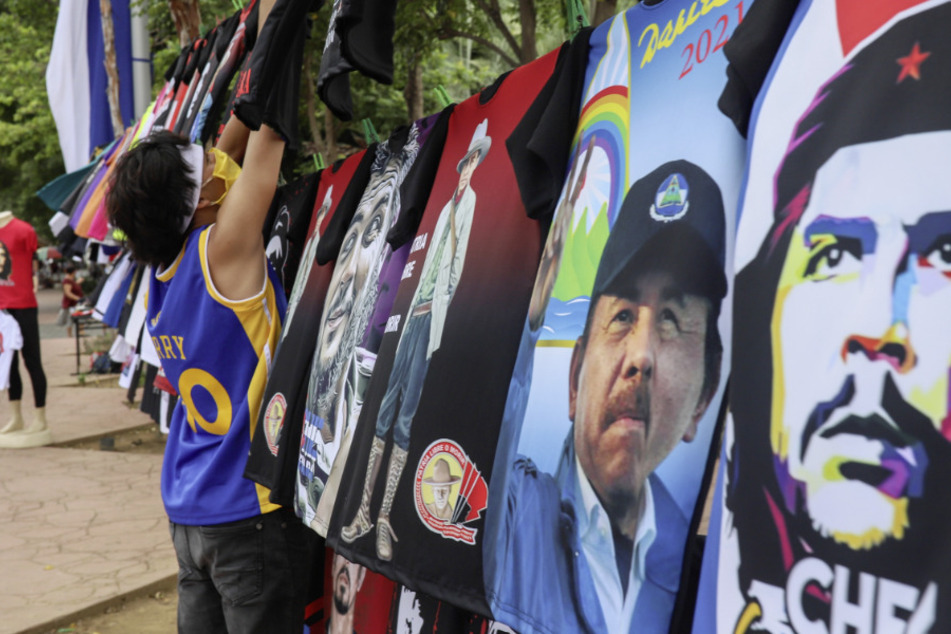 Ein Mann mit Mundschutz verkauft T-Shirts mit Abbildungen des nicaraguanischen Präsidenten Daniel Ortega oder des Revolutionsführers Che Guevara.