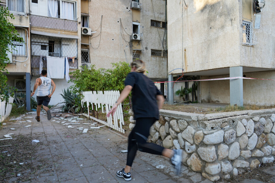 Israelis rennen, um Deckung zu suchen, als eine Sirene vor anfliegenden Raketen aus dem Gazastreifen warnt.