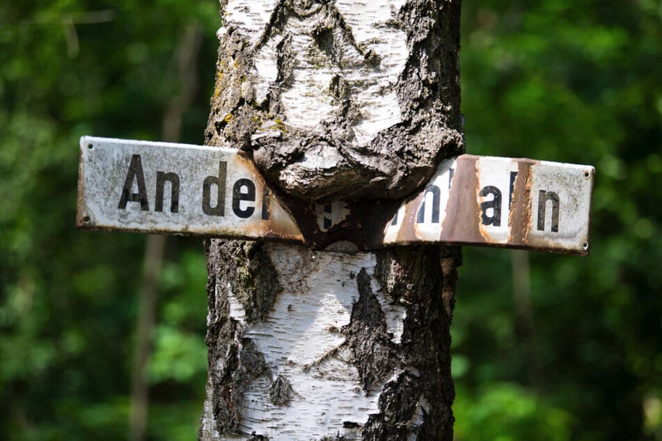 Ein altes, verwittertes Schild weist auf die historische Bahnstrecke hin.