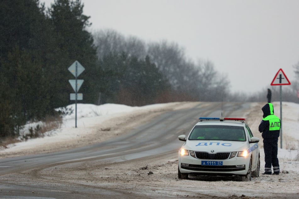 Traffic police are seen on a roadside outside the village of Yablonovo near the Russian IL-76 military transport plane crash site in the Belgorod region on January 24.