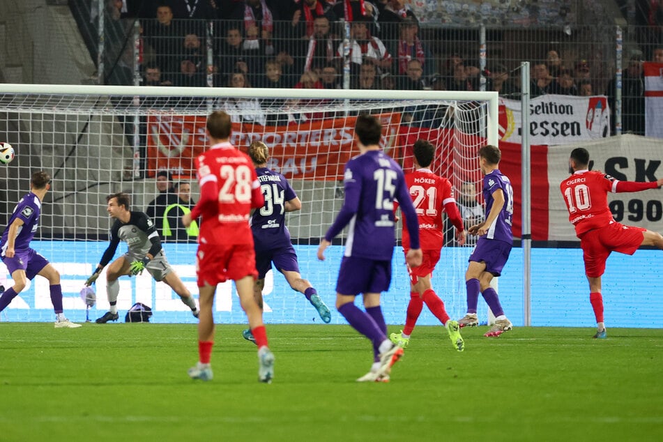 Cottbus-Spieler Tolcay Cigerci (r.) zieht zum 1:2 ab. Aue-Torwart Martin Männel (2. v. l.) sieht den Ball ins Netz flattern.