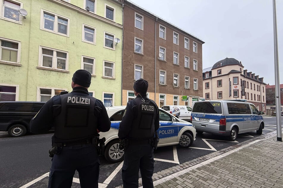 Polizeibeamte stehen vor dem Haus, in dem sich grausige Szenen abgespielt haben müssen.