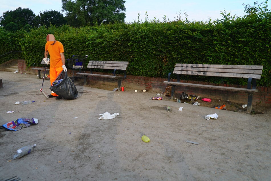 Ein Mitarbeiter der Stadtreinigung sammelt Müll im Stadtpark auf.