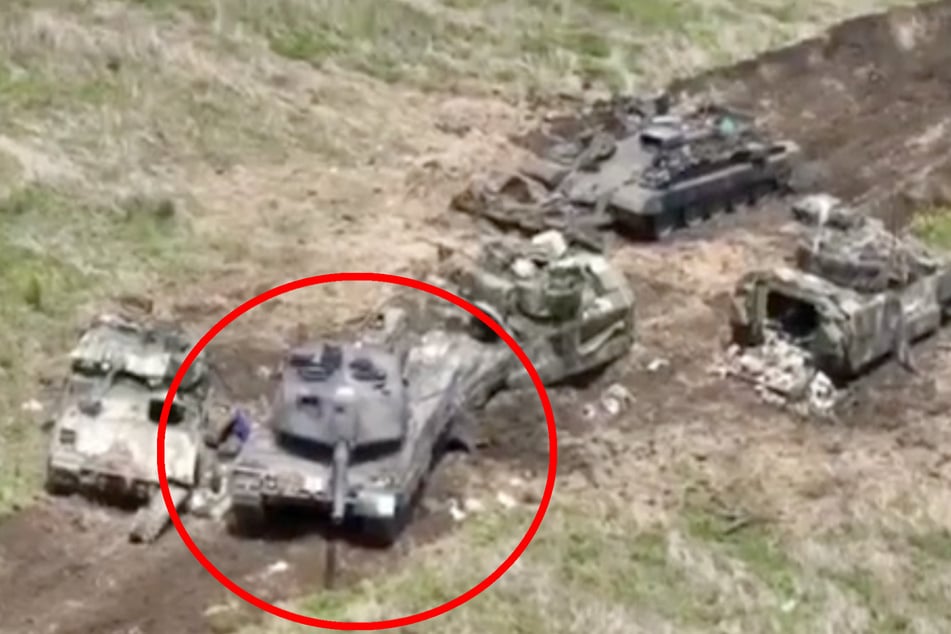 Ein Panzer, bei dem es sich um einen Leopard 2A6 handeln könnte, ist offenbar in einen russischen Artillerieschlag geraten. Daneben liegen drei völlig zerstörte Bradleys BMR und ein BMP-Schützenpanzer.