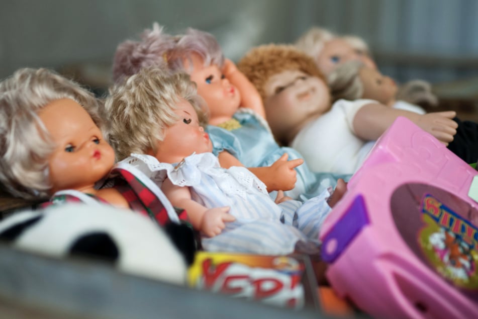 Puppen liegen in einer Gitterbox auf dem Wertstoffhof in Neustadt bei Coburg. Dort werden Spielzeuge gesammelt und von einem Mitarbeiter nach bestimmten Kriterien sortiert.