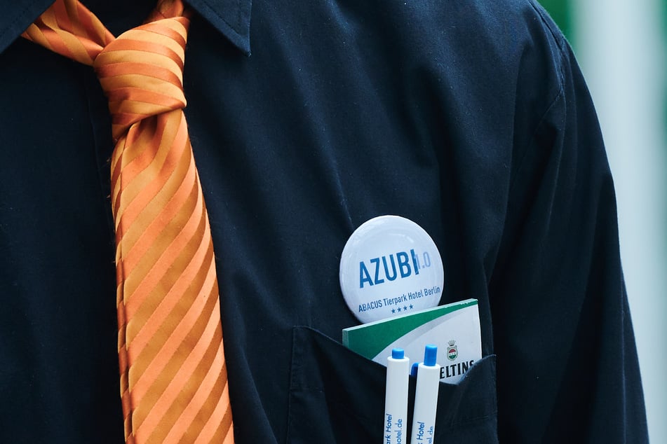 "AZUBI" steht auf dem Button eines Auszubildenden im Hotelfach im Restaurant des Abacus Tierpark Hotels.