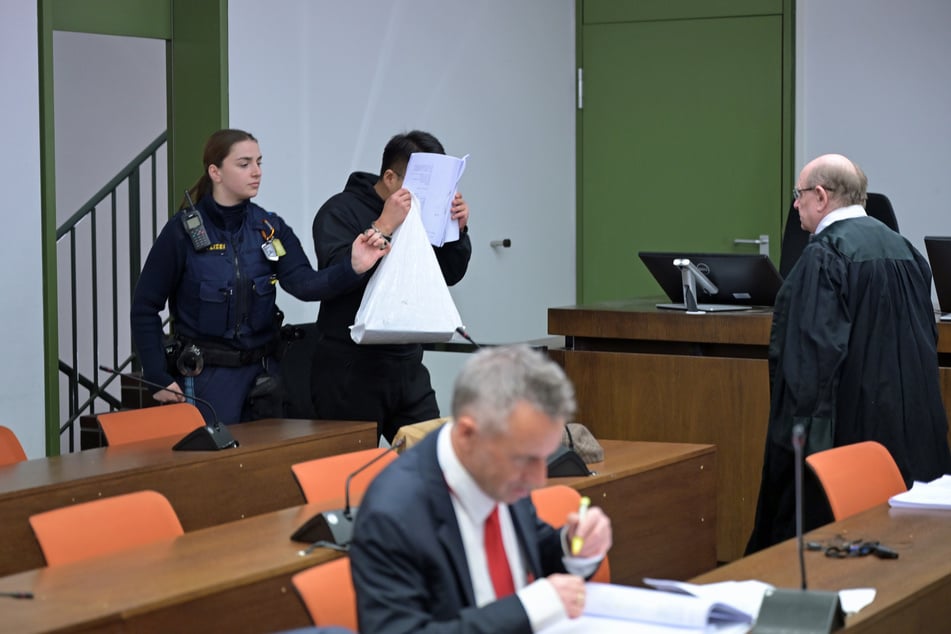 Der Student wird in den Gerichtsaal geführt. Er ist unter anderem wegen versuchten Mordes in sieben Fällen angeklagt.