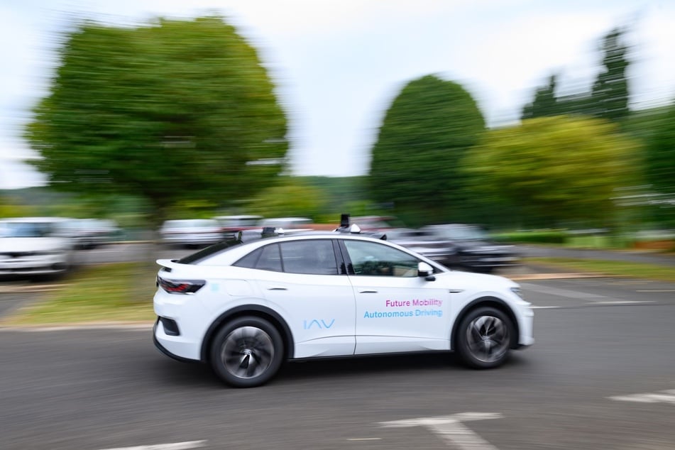 Ein Volkswagen ID.5 des Berliner Unternehmens IAV fährt im Rahmen einer Präsentation zu einem Projekt zum autonomen Fahren im Öffentlichen Personennahverkehr im sächsischen Dorfhain über einen Parkplatz.