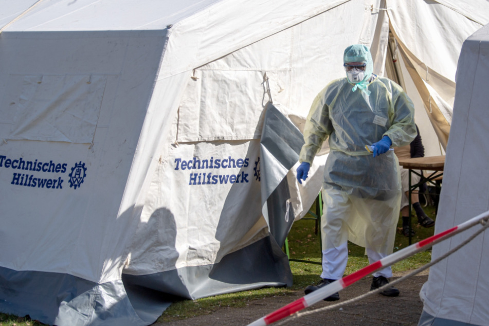 Ein Klinik-Mitarbeiter geht im Schutzanzug durch eine provisorische Ambulanz. (Symbolbild)
