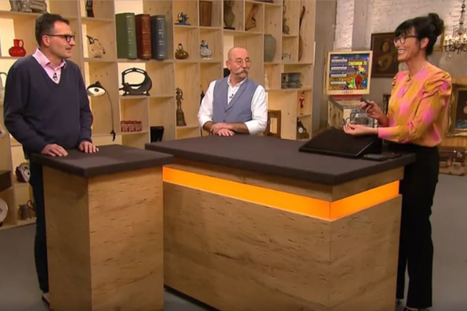 Christian Boeck (l.) möchte bei "Bares für Rares" eine Brosche verkaufen, die er einst für vier Euro auf einem Flohmarkt erstanden hat.
