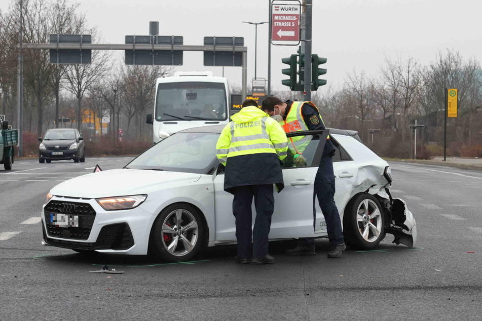 Polizisten untersuchen den beschädigten Audi.