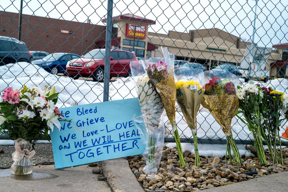 Mourners placed flowers and messages outside the grocery store where the shooting took place.