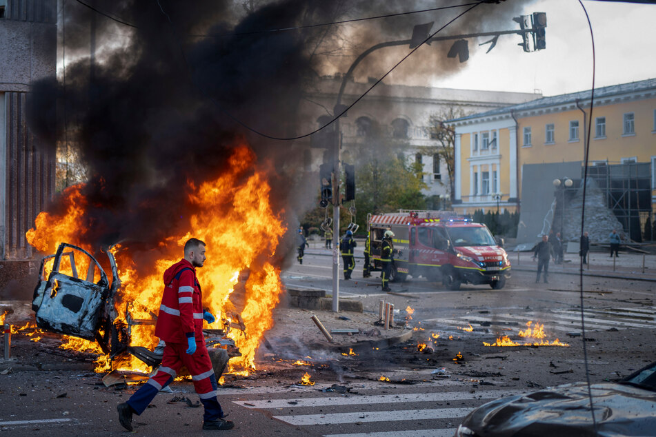 Ein Sanitäter geht an einem brennenden Auto nach einem russischen Angriff vorbei. Nach russischen Raketenangriffen ist der Luftalarm in der ukrainischen Hauptstadt Kiew nach mehr als fünfeinhalb Stunden aufgehoben worden.