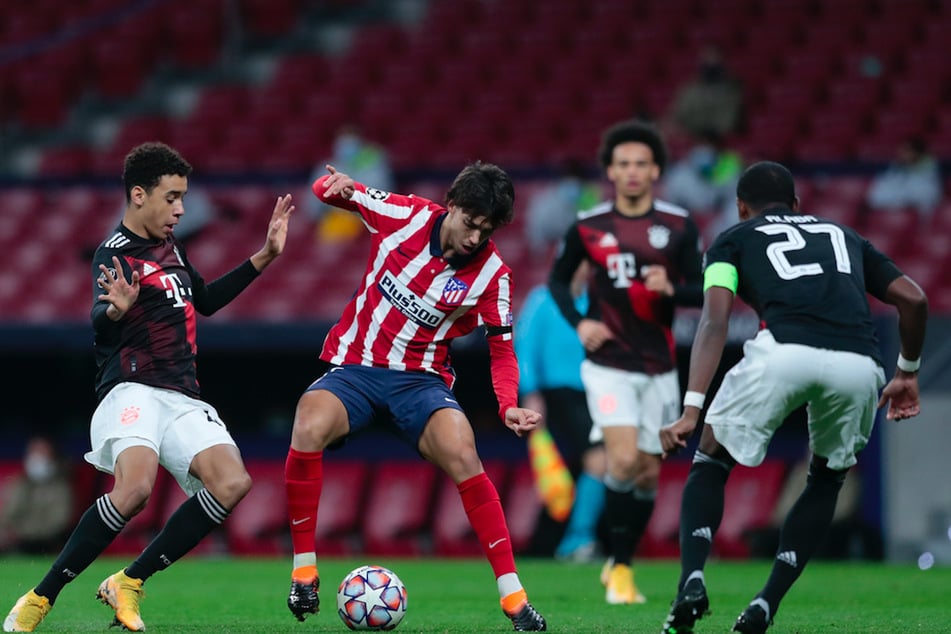 Joao Felix (M.) von Atletico Madrid kämpft mit Jamal Musiala (l.) vom FC Bayern um den Ball.