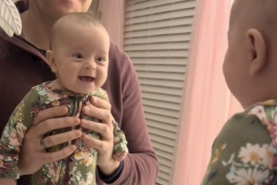 Der Moment, der so viele glücklich machte: Baby Presley muss beim Blick in den Spiegel herzlich lachen.