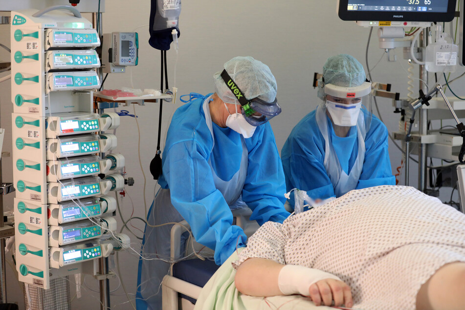 Im Infektionszimmer für Covid-19-Patienten auf der Intensivstation der Universitätsmedizin Rostock wird ein Patient im künstlichen Koma gepflegt. Die Zahl der Todesfälle bleibt in Deutschland auf hohem Niveau.