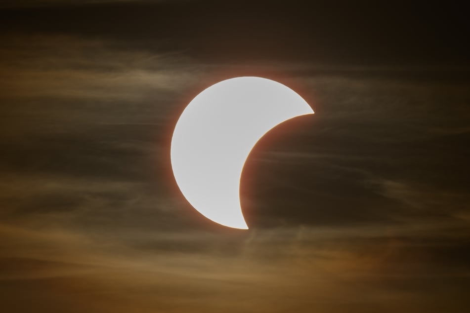 Der Beginn einer partiellen Sonnenfinsternis ist am Himmel über Dresden zu sehen.