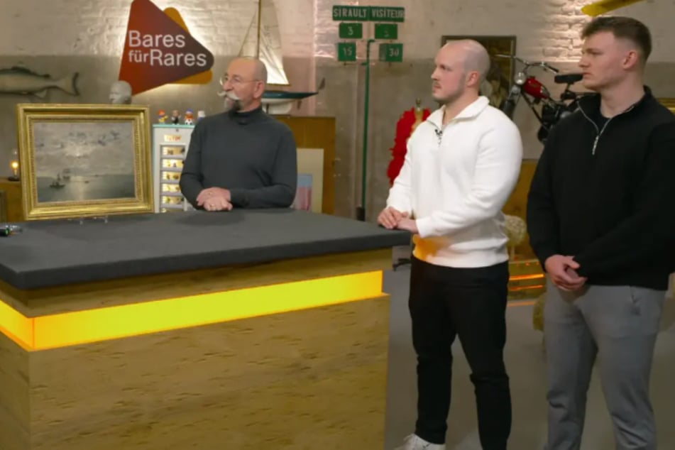 Niklas Müller aus Sankt Augustin und Jonas Rösler (r.) aus Siegburg wollen bei "Bares für Rares" ein altes Ölgemälde von Alfred Wahlberg (1834–1906) verkaufen.