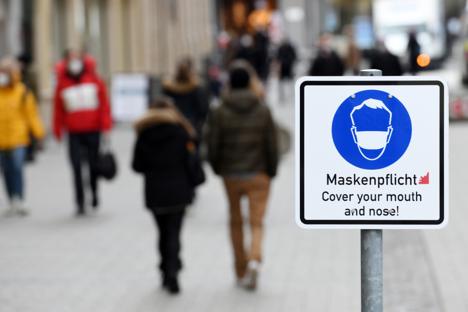 Ein Schild weist in der Münchner Innenstadt auf die Maskenpflicht innerhalb der Fußgängerzone hin.