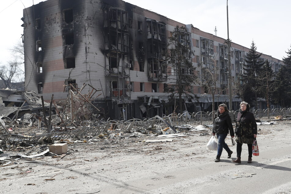 Bewohner gehen am 10. April 2022 in der Nähe von beschädigten Gebäuden in Mariupol, nach Abzug russischer Truppen. Nun soll die ukrainische Stadt erneut Ziel russischer Luftangriffe gewesen.