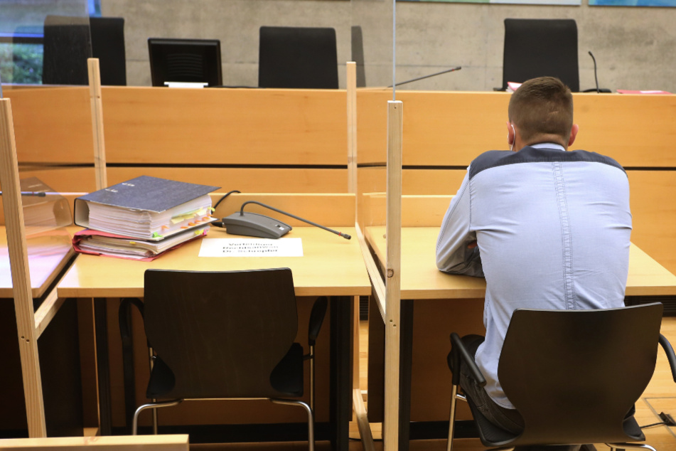 Der Angeklagte sitzt in einem Gerichtssaal im Landgericht auf der Anklagebank.