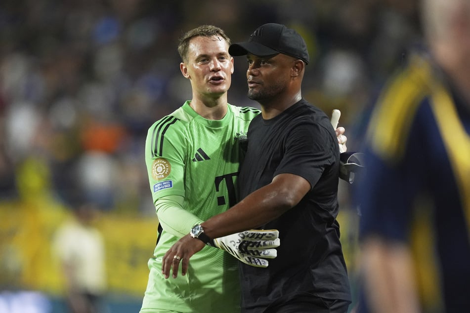 Manuel Neuer (39, l.) und Trainer Vincent Kompany (39) halten auf dem Spielfeld zusammen.