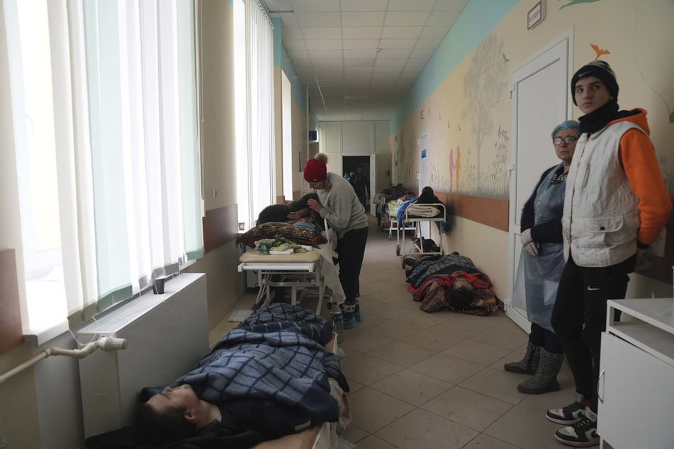 Durch Granatenbeschuss verletzte Menschen liegen im Flur eines Krankenhauses in Mariupol.