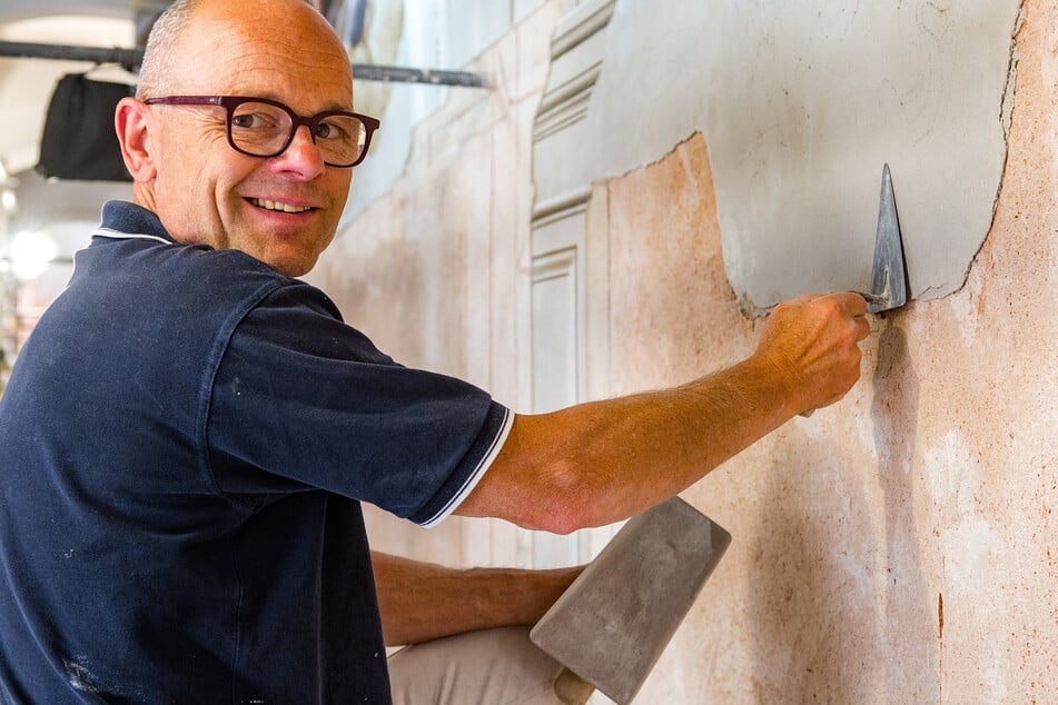 Stuckateurmeister André Glauche (59) trägt auf rötlichem Ziegelsplitt den Kalkputz auf, der bearbeitet und bemalt werden muss, solange er noch feucht ist.