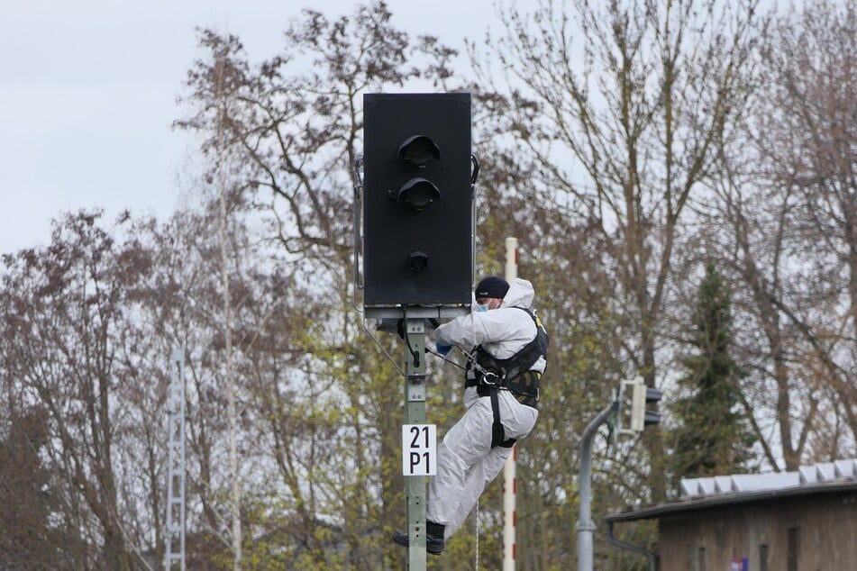 Ein Kriminalist hat einen betroffenen Signalmast erklommen und versucht dort, DNA-Spuren zu sichern.