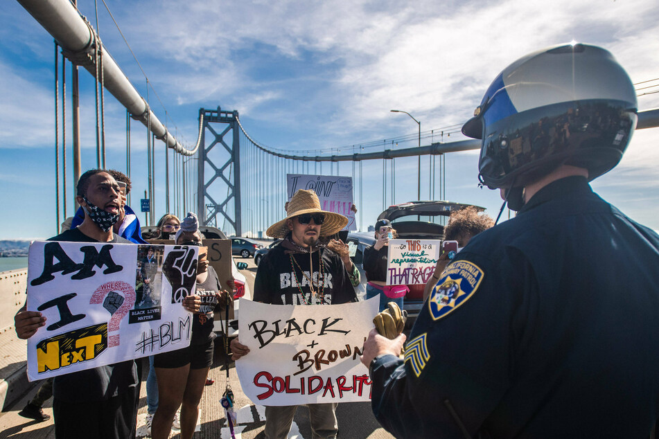 BLM protestors in front of a police officer on Bay Bridge on June 14, 2020 after the death of George Floyd.