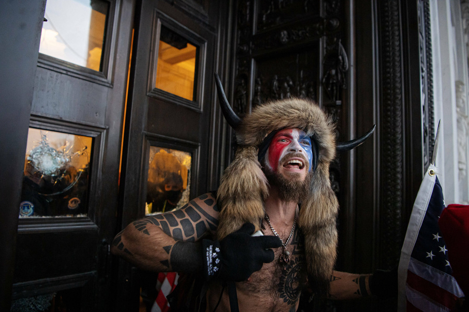 QAnon Shaman Jacob Anthony Chansley, a.k.a. Jake Angeli, stands outside the main entrance to the US Capitol.