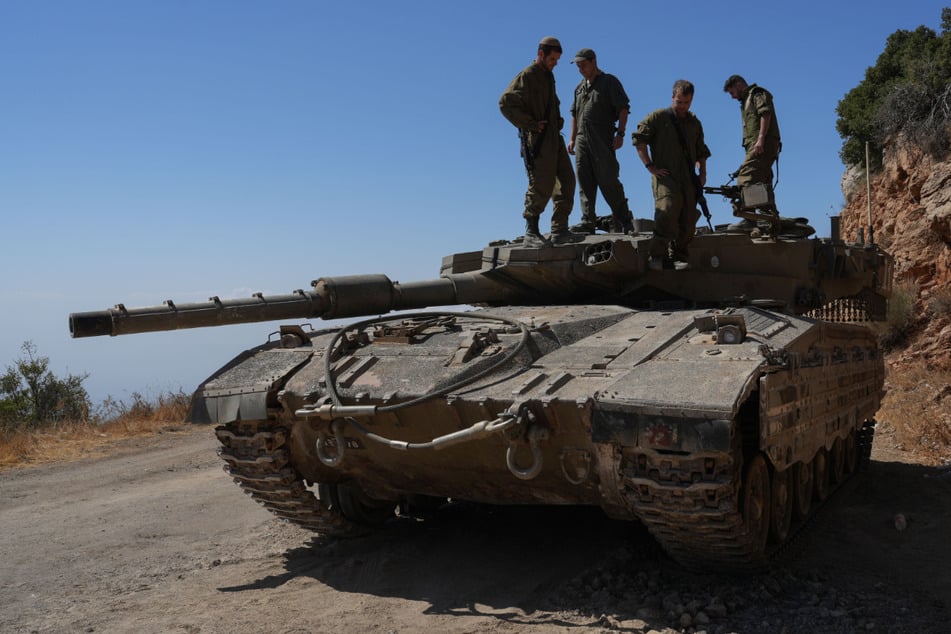 Israelische Reservesoldaten stehen auf einem Panzer nahe der nordisraelischen Grenze zum Libanon.