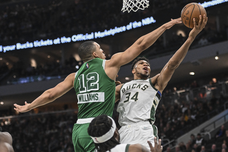 Giannis Antetokounmpo (r.) goes up against the Celtics' Grant Williams.