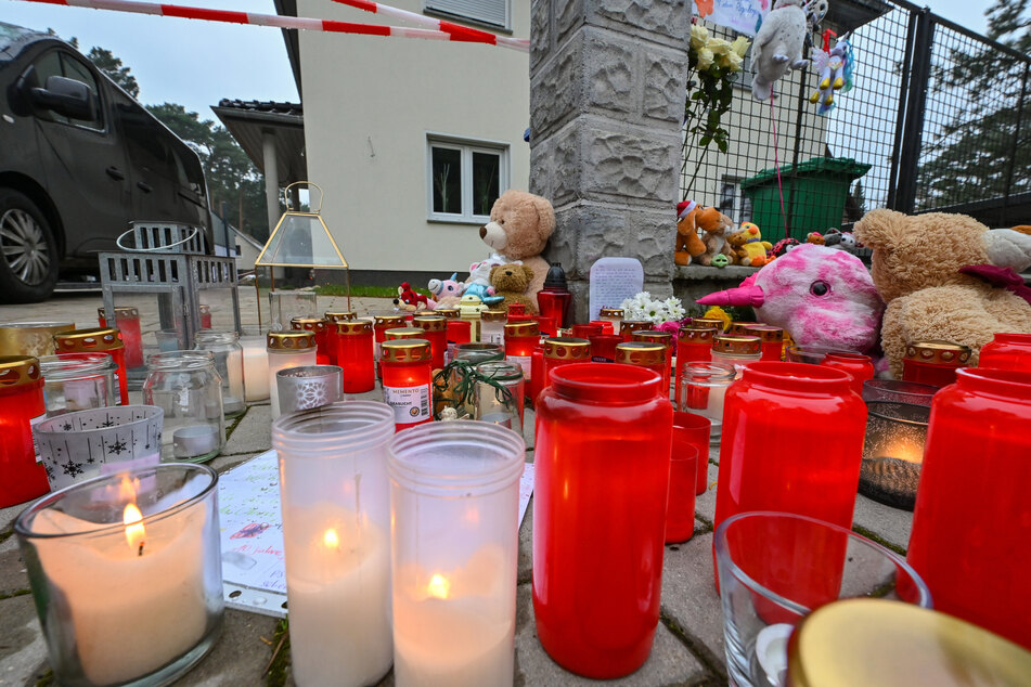 Viele Kerzen brennen vor auf einem Gehweg vor einem Einfamilienhaus im Ortsteil Senzig der Stadt Königs Wusterhausen im Landkreis Dahme-Spreewald. Am 4. Dezember hatten Zeugen in diesem Einfamilienhaus leblose Personen gesehen und die Polizei alarmiert. Die Beamten fanden die fünf Bewohner des Hauses tot vor. Darunter waren auch drei Kinder im Alter von 4, 8 und 10 Jahren. Die beiden Erwachsenen waren jeweils 40 Jahre alt.