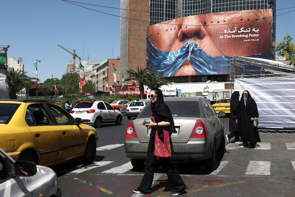 People walk past an anti-US billboard depicting President Donald Trump and the Strait of Hormuz, in Tehran, Iran, on May 25, 2026.
