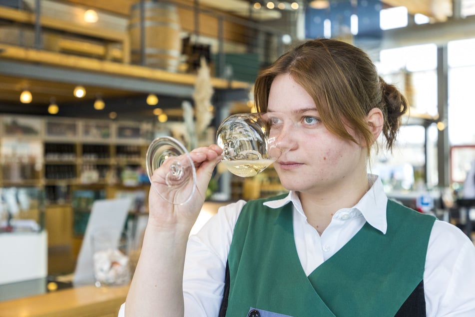 Die künftige Restaurantfachfrau Matilde Adam (19) prüft das Buket ihres Scheurebe-Lieblings.