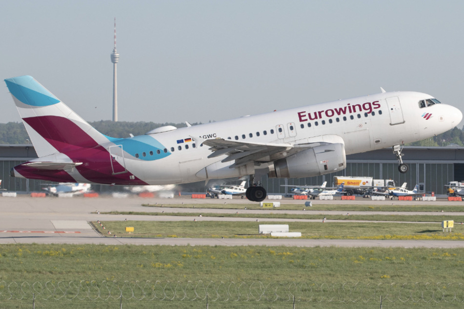 Ein Flugzeug der Eurowings startet auf dem Flughafen Stuttgart, im Hintergrund ist der Fernsehturm zu sehen.
