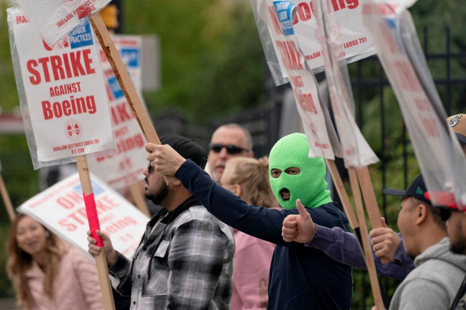 Boeing factory workers and supporters gather on a picket line during the third day of a strike near the entrance to a production facility in Renton, Washington.