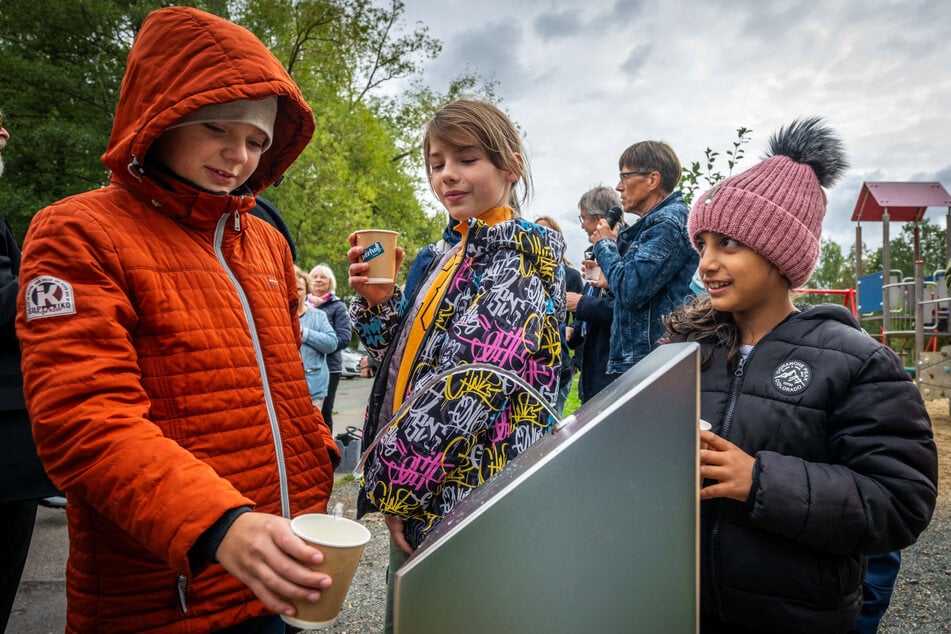 Kinder aus dem Wohngebiet testen den Brunnen.