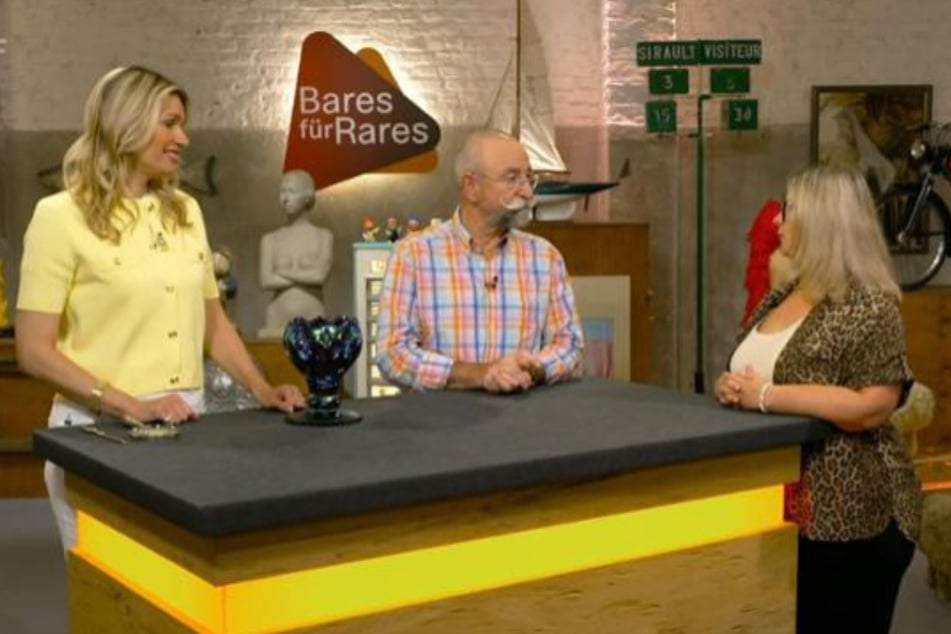 Andrea Fritsch (42 r.) aus Bad Rappenau möchte bei "Bares für Rares" ein buntes Glasgefäß mit bewegter Vergangenheit zu Geld machen.